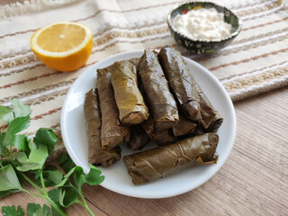 Traditional oriental Turkish dolma made of grape leaves stuffed with rice on a decorative plate