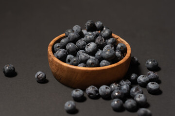 Delicious fresh sweet blueberries on a dark background, a bowl of blueberries in dark background, Blueberries in a wooden bowl on a black, healthy food