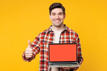 Young IT man wears red checkered shirt casual clothes hold use work on laptop pc computer with...