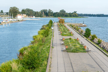 View of the promenade, Walking along the promenade, Landscape with a lake and a sidewalk, a tourist...