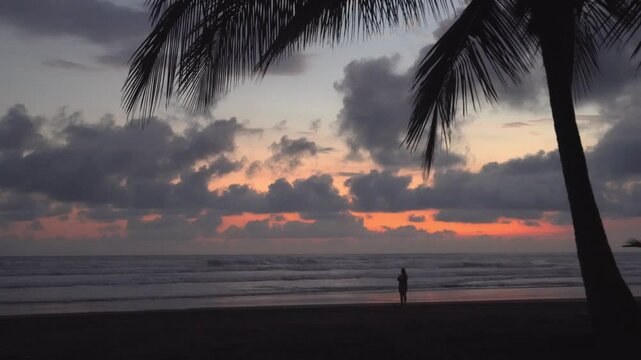 The ocean is calm and the sky is a beautiful orange color. The water is a deep blue color