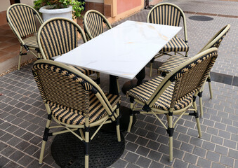A set of chairs and tables outside the coffee shop