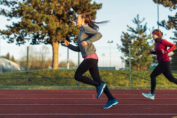 Women Stretching on a Running Track at Sunset