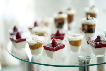 A sweet dessert table of mousses decorated with berries.