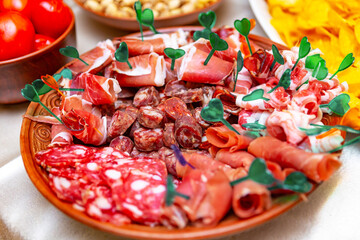A Colorful Charcuterie Platter With Assorted Meats and Garnishes at a Gathering.