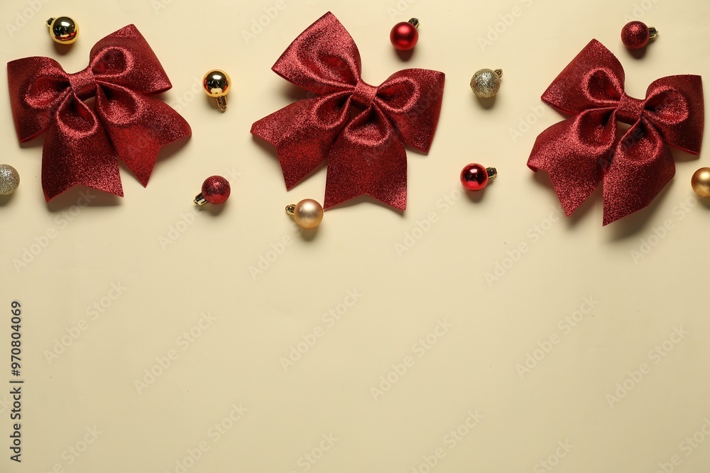 Wall mural christmas balls and bows on beige background, flat lay. space for text