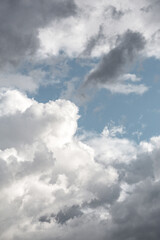 Dynamic sky filled with fluffy white clouds and darker storm clouds set against a blue background