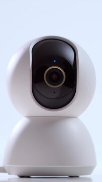 Surveillance digital video cam rotating on white background. CCTV ensuring privacy, security and safety. Concept of a remote guard system. Vertical video.
