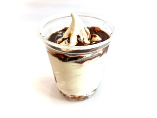 Delicious vanilla ice cream with chocolate syrup in a plastic cup isolated on white background