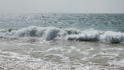 Fototapeta premium Waves of sea water crashing into the beach in coastal Karnataka, India
