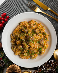 Rice paella with Iberian pork cheek. Top view table with Christmas decoration.