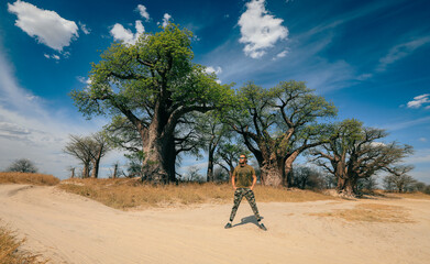 A tourist exploring the stunning landscapes of Botswana among ancient baobab trees on a sunny day