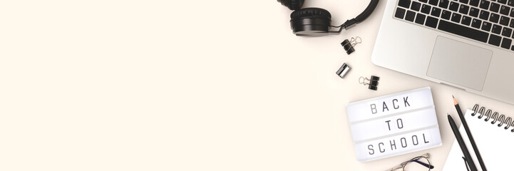 Back to school. Banner with lightbox, laptop and office supplies on a gray background.