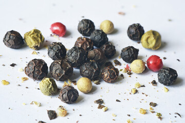 Close up photograph of dry colourful peppercorn mix. Food spices for cooking. Macro, details and texture, realistic. Isolated on white background.