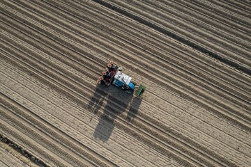 Tractor working on a plowed field from above