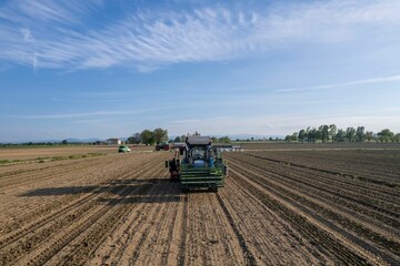 Tractor working in an agricultural field under a blue sky