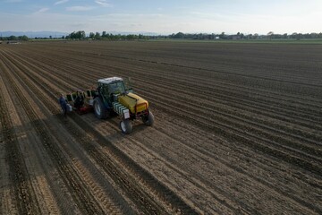 Obraz premium Tractor working in a vast agricultural field.