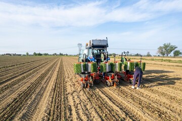 Obraz premium Farmer working in a large agricultural field with modern tractor