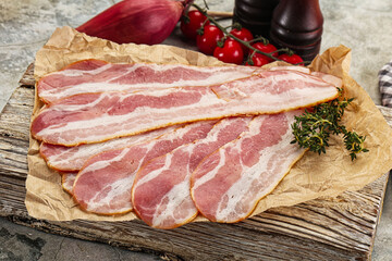 Sliced pork bacon over board
