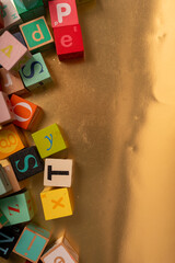 Colorful alphabet blocks scattered on a golden surface Ready to spell out your imagination...