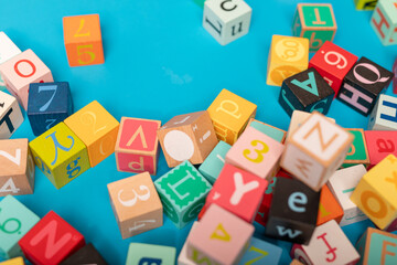 Colorful alphabet blocks scattered on a blue background Learning and playing