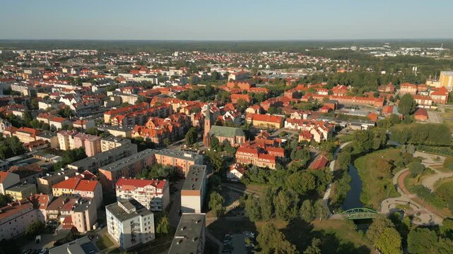 Panoramic drone shot of Elk green city surrounded by forest and lake, St. Wojciech Cathedral church and gothic buildings
