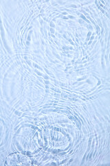 Close-up of a water surface with gentle ripples and circular waves. The soft, calming image emphasizes the soothing nature of water, perfect for promoting spa products or beauty products.
