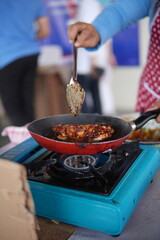 a woman cooking grilled chicken