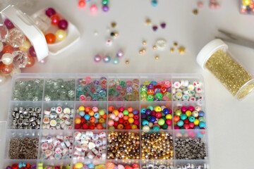 Making friendship bracelets with letter beads. Jewelry making supplies on the table. Selective focus.