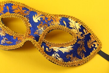 One beautiful carnival mask on yellow background, closeup