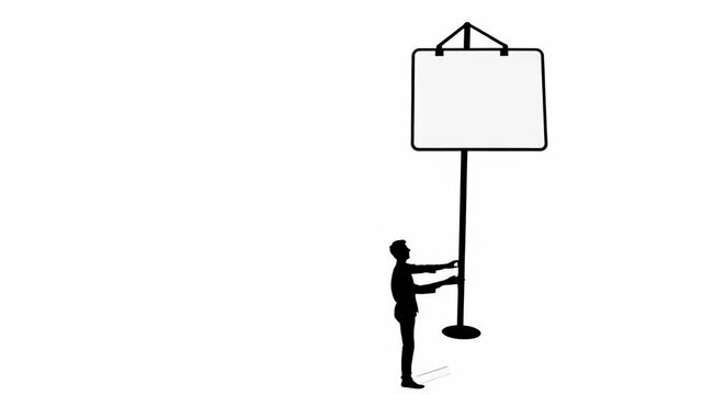 Silhouette of a man adjusting a large hanging sign on a stand.