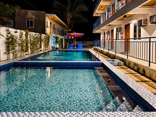 Real, Quezon Province, Philippines - June 10, 2024: A cozy, well-lit boutique resort at night featuring a tranquil swimming pool, creating an inviting atmosphere for relaxation.