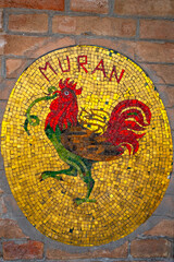 Antique fresco of the famous Murano glass on a brick wall on the island of Murano, Italy