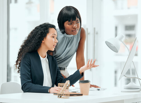 Women, supervisor and talking at computer in office for online system error, internet glitch or explain mistake. Collaboration, business people or manager with assistance, advice or helping at desk