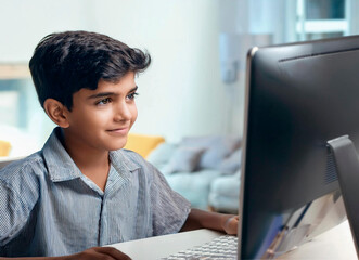 Indian young school boy attending online classes in front of the computer