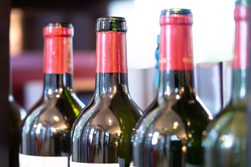 Close-up of wine bottles stacked against a bokeh light background