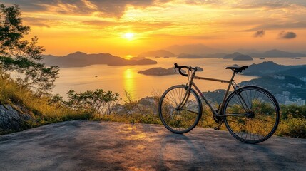 Fototapeta premium A bicycle rests on a scenic overlook during a vibrant sunset over the water.