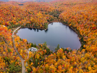Aerial view of heart shape lake surrounded by autumn forest. Concept of earth day, love, environment, ecology. Baker Pond, Bolton-Est, Quebec, Canada.