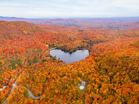 Aerial view of heart shape lake surrounded by autumn forest. Concept of earth day, love, environment, ecology. Baker Pond, Bolton-Est, Quebec, Canada.