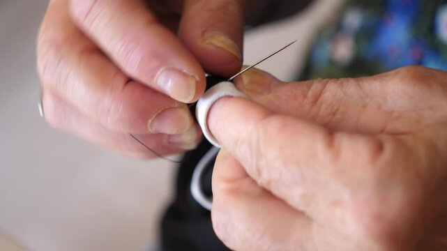 Hands mending a torn bra, side view of detailed repair work. The stitching process is shown from a lateral perspective, highlighting the care taken.