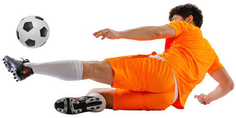 Dynamic image of determined athlete, soccer player in orange football kit training falling down while kicking ball isolated on white transparent background. Concept of sport, competition, game