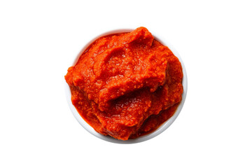 Obraz premium A close-up of red pepper paste in white ceramic bowl isolated on white transparent background. Concept of condiment, seasoning or dip