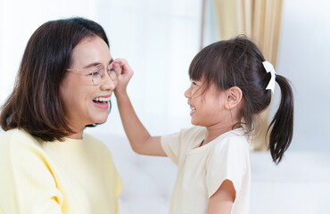 Child playing with mother in room, Asian mother enjoying with daughter at home