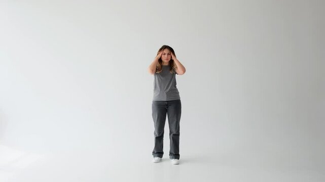 Sad Caucasian young adult woman suffering from headache on white background. Concept of a health problem, exhaustion, annoyance and anxiety.