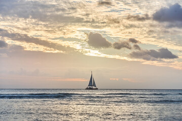 Beautiful sunset over the ocean and a small yacht 