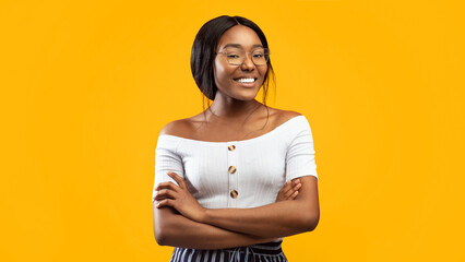 Obraz premium Cheerful African American Girl Crossing Hands Smiling At Camera Standing In Studio On Orange Background. Panorama