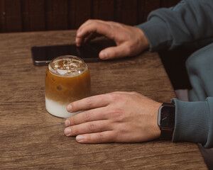 person holding a glass of latte 