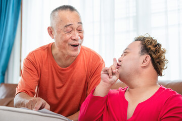 Senior man and grandchild practice math skill, interactive math game, Grandfather supervising grandchild sitting at sofa doing homework