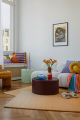 Vibrant interior featuring soft, comfy seating, bold prints, and fresh flowers for a welcoming...