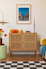 Fresh blooms in bright orange and yellow sit atop a wooden sideboard, framed by geometric decor and...